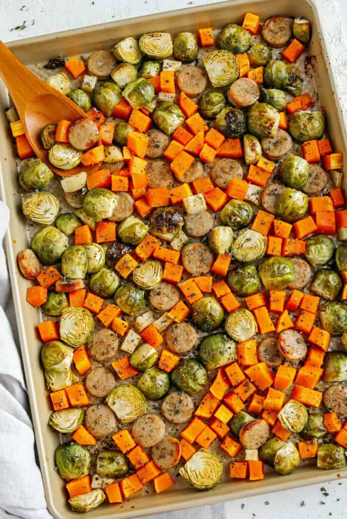 Harvest Sheet Pan Sausage and Veggies loaded with flavorful chicken sausage, butternut squash, brussels sprouts, and apples for a quick and easy dinner made in just 30 minutes! Roasted in a maple mustard glaze and fresh herbs for the perfect fall meal!