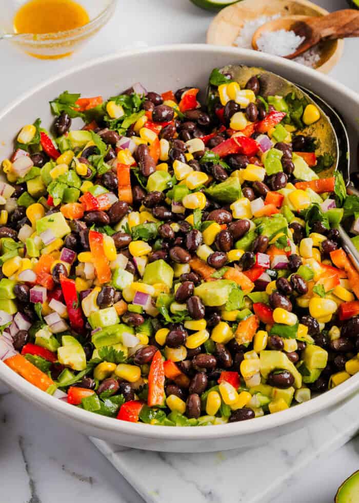 This Black Bean and Corn Salad is loaded with crisp veggies, delicious spices and fresh cilantro, all tossed together in a zesty lime dressing making it the perfect summer side dish or dip!