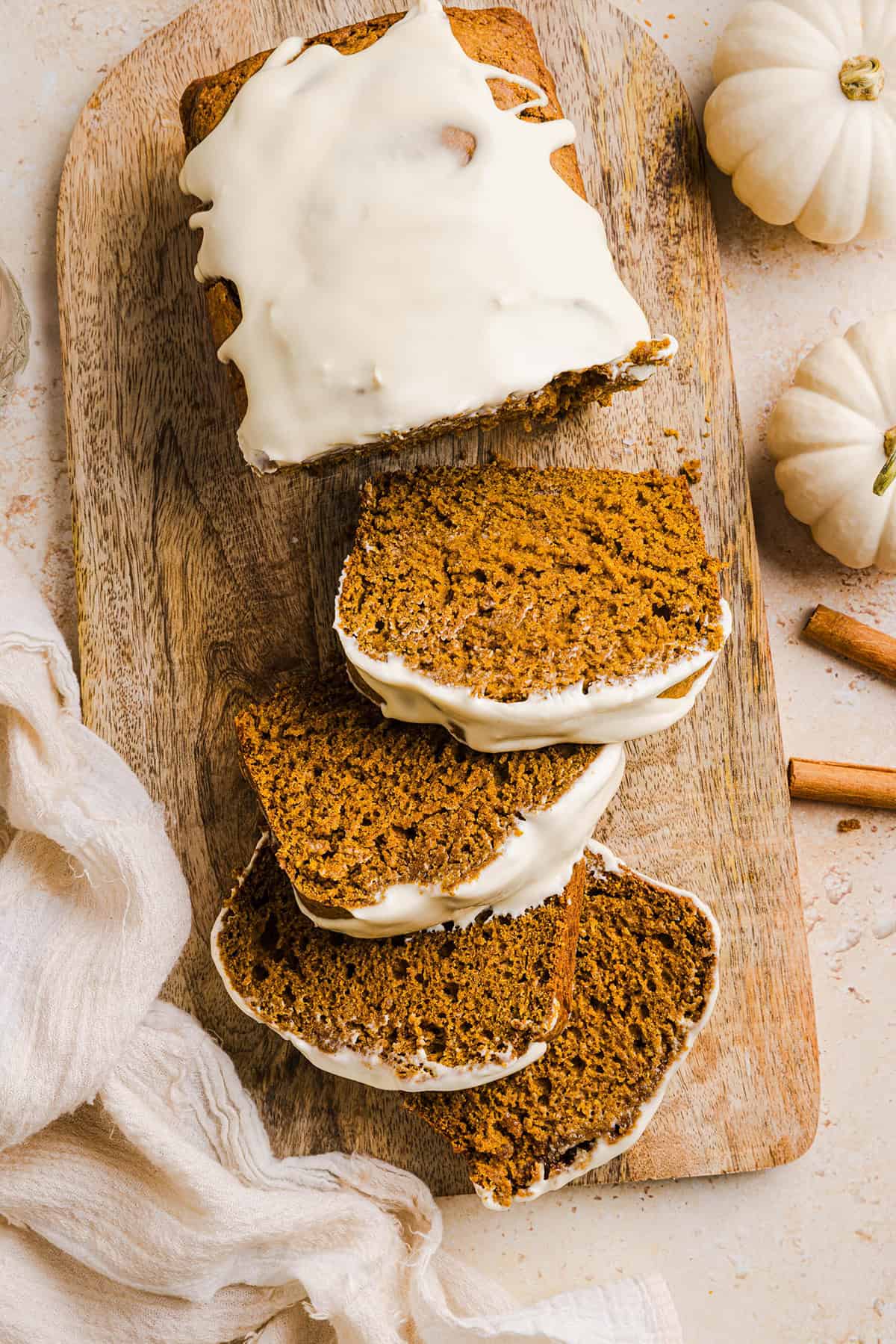 The BEST Healthy Pumpkin Bread that is moist, loaded with pumpkin flavor and made without any butter or refined sugar! Topped with a delicious maple cream cheese glaze for the perfect fall treat this season!