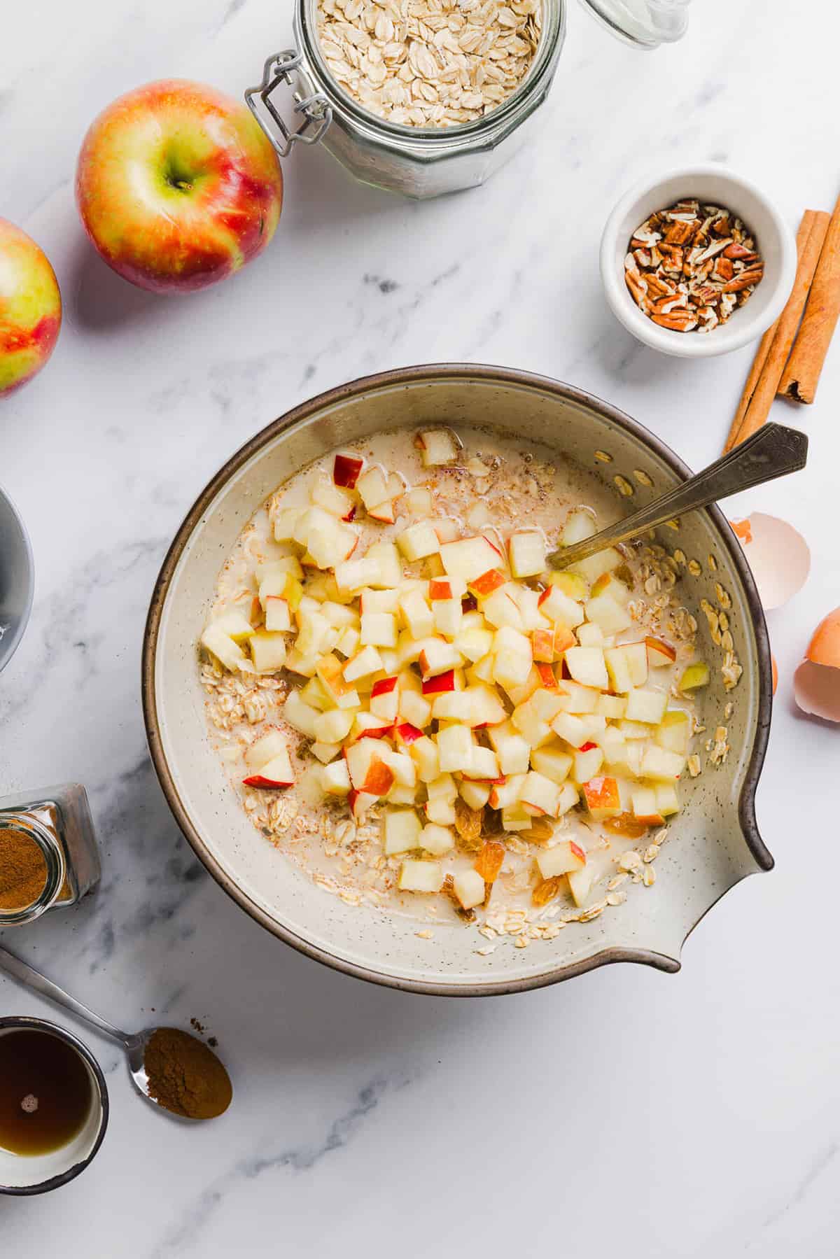 This Apple Cinnamon Baked Oatmeal is a cozy breakfast made with wholesome oats, shredded apples, and warm spices while naturally sweetened with maple syrup and plump raisins!  We also topped this with crunchy pecans and a delicious maple cream cheese glaze!