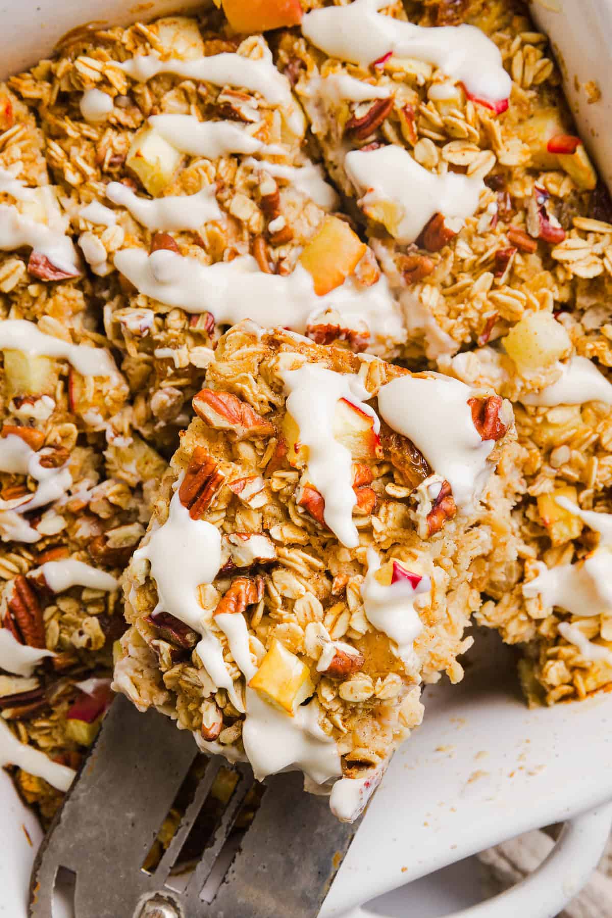 This Apple Cinnamon Baked Oatmeal is a cozy breakfast made with wholesome oats, shredded apples, and warm spices while naturally sweetened with maple syrup and plump raisins!  We also topped this with crunchy pecans and a delicious maple cream cheese glaze!